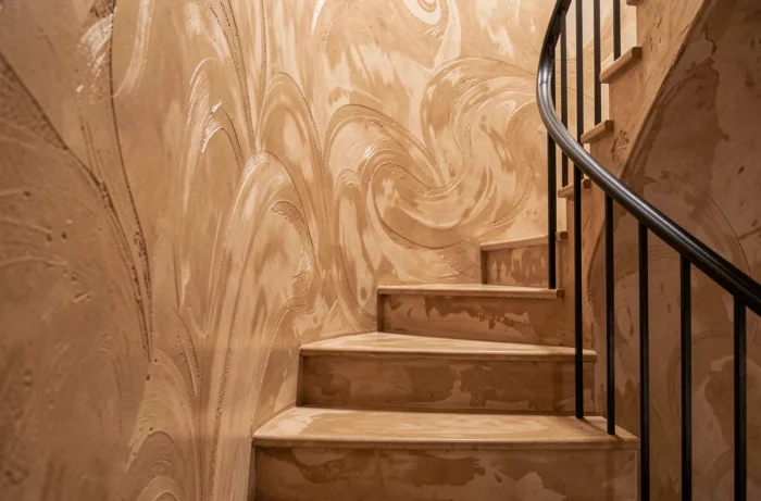 Mur de montée d'escalier recouvert d'un enduit tadelakt poli en teinte sable chaud