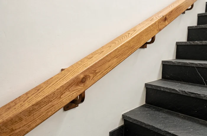 Main courante en chêne massif avec platine de fixation invisible sur escalier mural