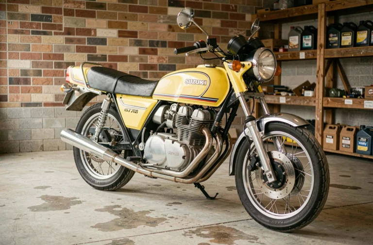 Suzuki GT 750 vintage 1973 couleur Candy Lemon Yellow garée dans un garage avec murs en briques apparentes